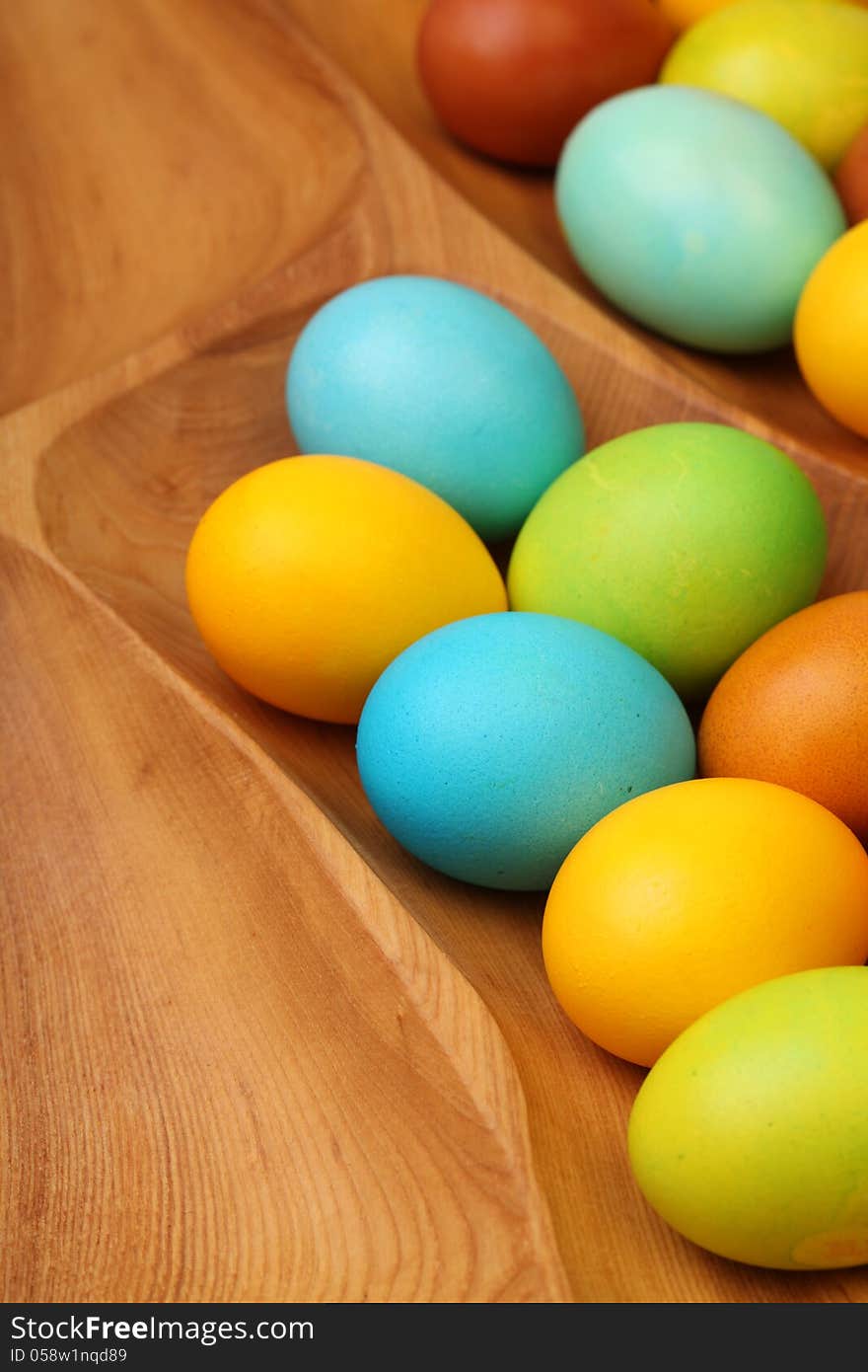 Colorful easter eggs in wooden tablemat.