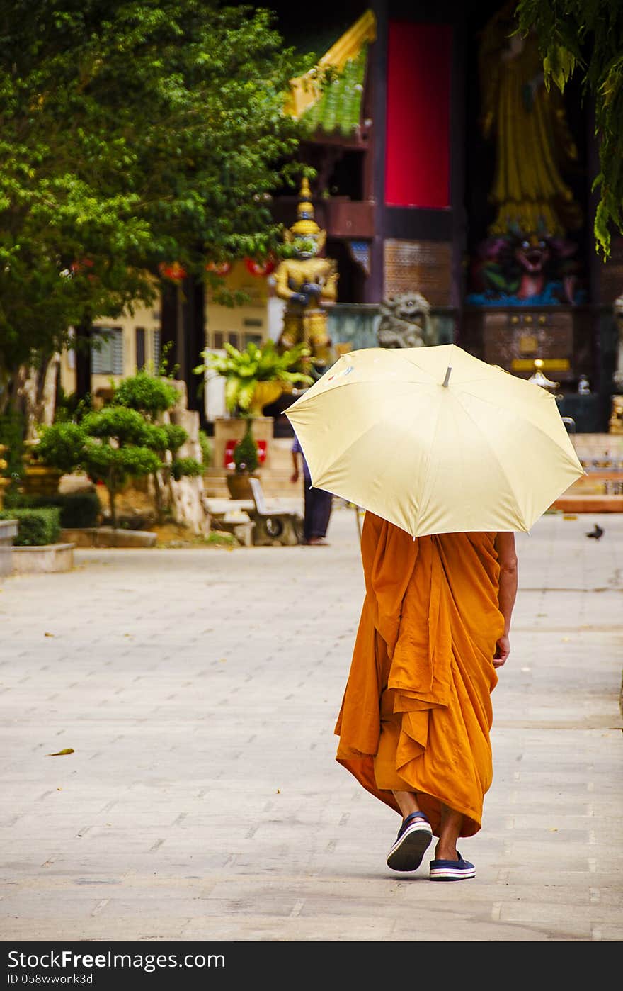 Buddhist monk with an umbrella at a Thai Temple