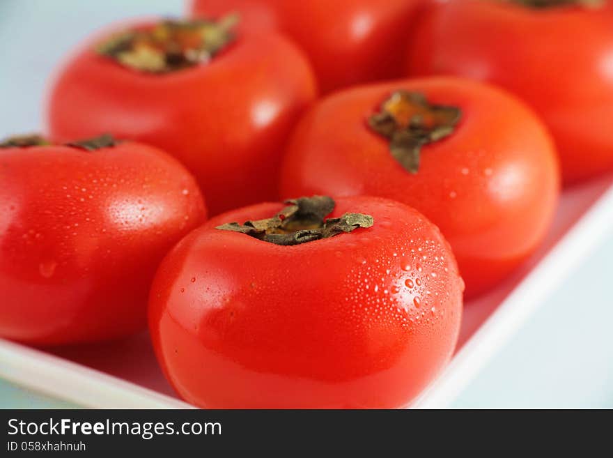 Frsh persimmon with droplet in dish