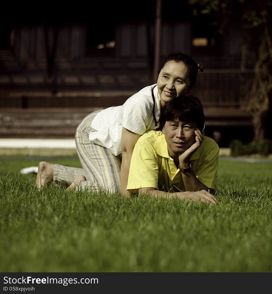 Portrait of beautiful couple lie on ground in park relaxing