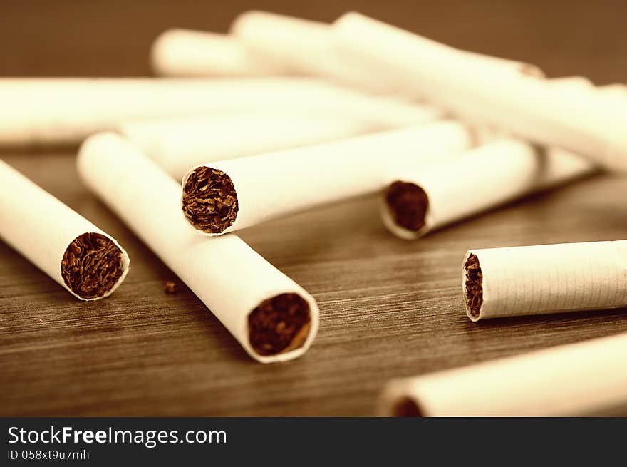 Heap of cigarettes and tobacco on a dark wooden background