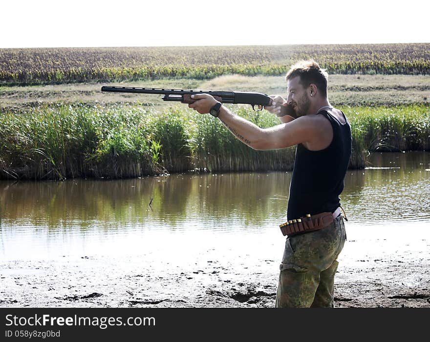 Young hunter with rifle at summer hunting season