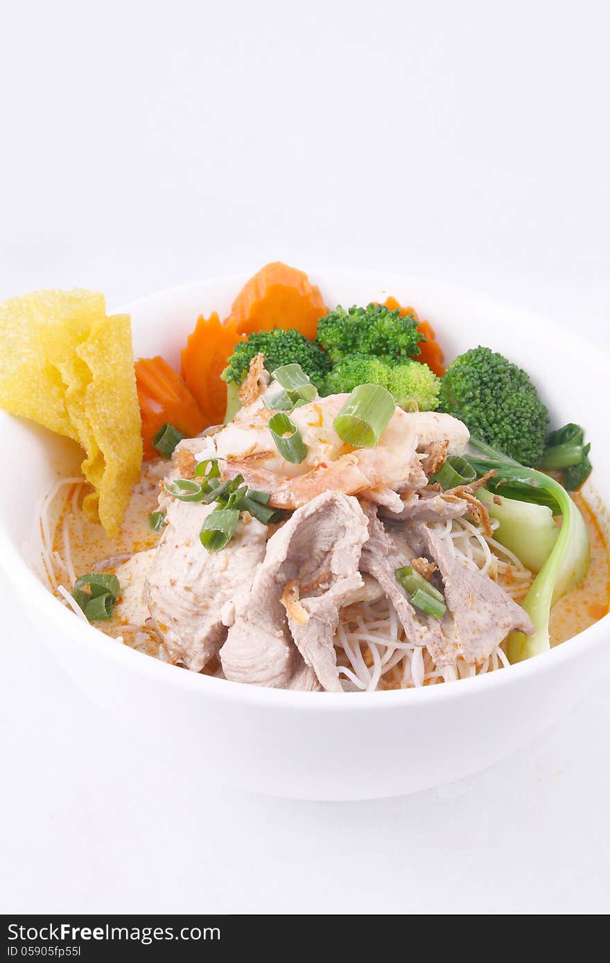 Laksa noodle soup with chicken, fresh vegetables and wonton on t