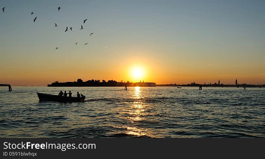 Anglers in boat fishing at sunset