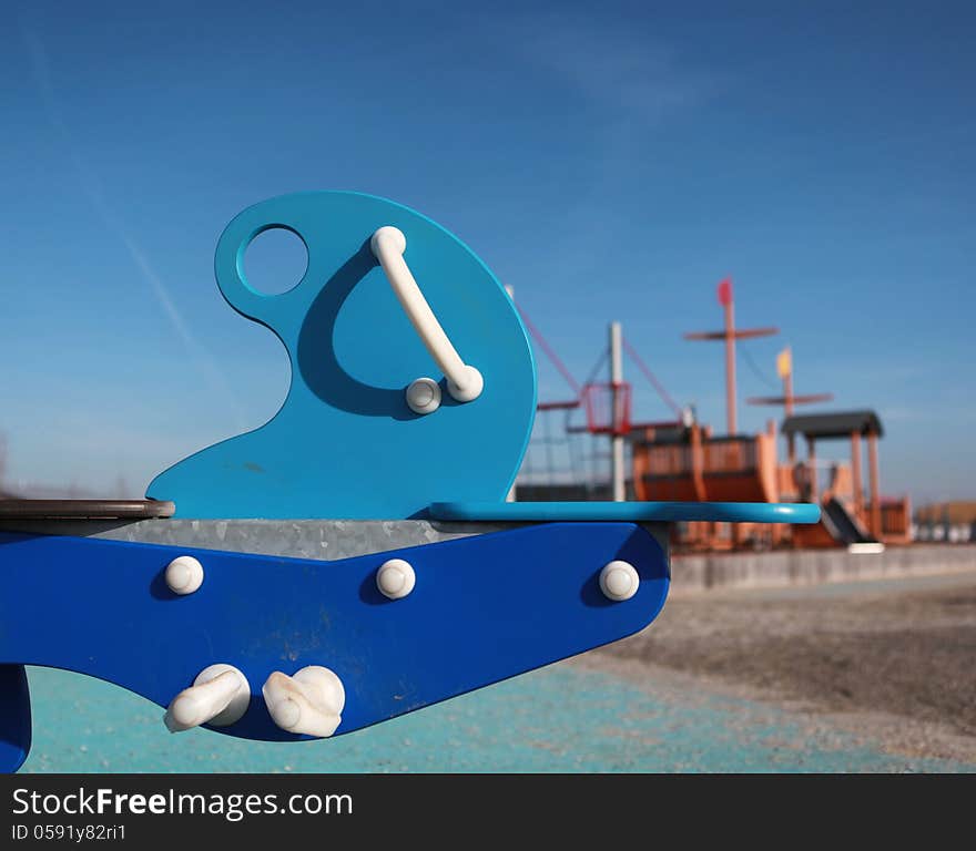 A blue rocking toy in a childrens playground. A blue rocking toy in a childrens playground.