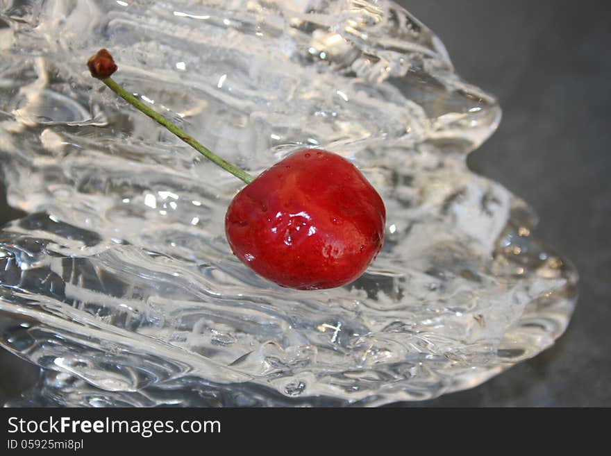 Single cherry laying on a piece of ice. Single cherry laying on a piece of ice.