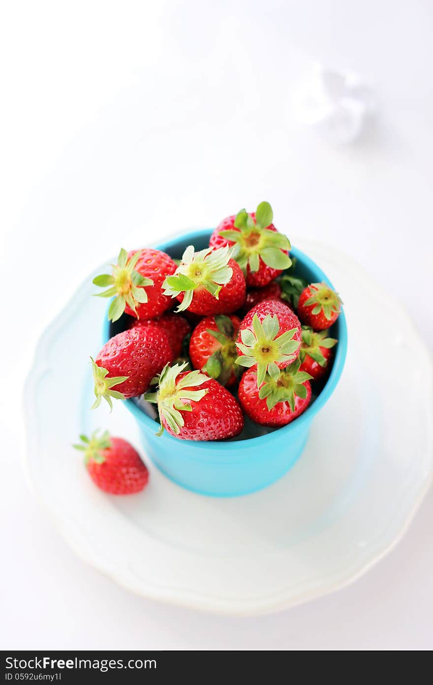 Blue pot with strawberries on white backgrownd