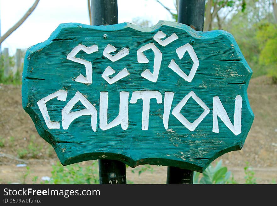 Caution Sign Thai and English Language on wooden sing