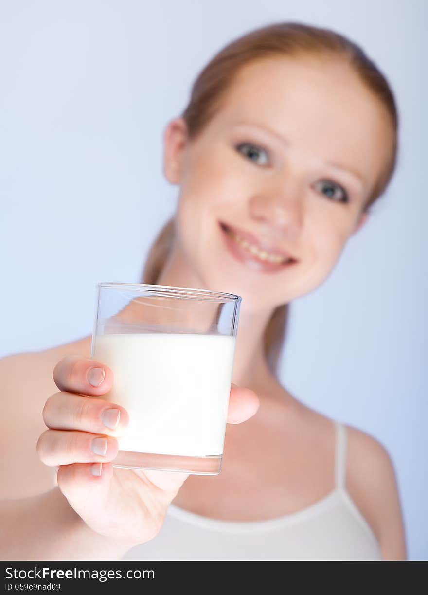 Beautiful healthy girl with a glass of milk on a blue background