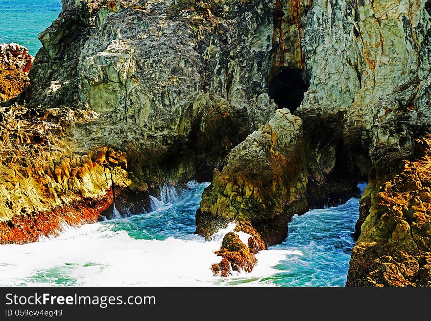 A rare and amazing view front on of the treacherous rocks facing the sea, of the face of a very high cliff. The surf waves continually rollling in and crashing onto the rock surface has provided some amazing textures,vivid colors and stunning landscape. Photograph taken from a remote point below the cliff at Point Lookout, Stradbroke Island, Queensland, Australia which is only a ferry ride from Brisbane cit. A rare and amazing view front on of the treacherous rocks facing the sea, of the face of a very high cliff. The surf waves continually rollling in and crashing onto the rock surface has provided some amazing textures,vivid colors and stunning landscape. Photograph taken from a remote point below the cliff at Point Lookout, Stradbroke Island, Queensland, Australia which is only a ferry ride from Brisbane cit.