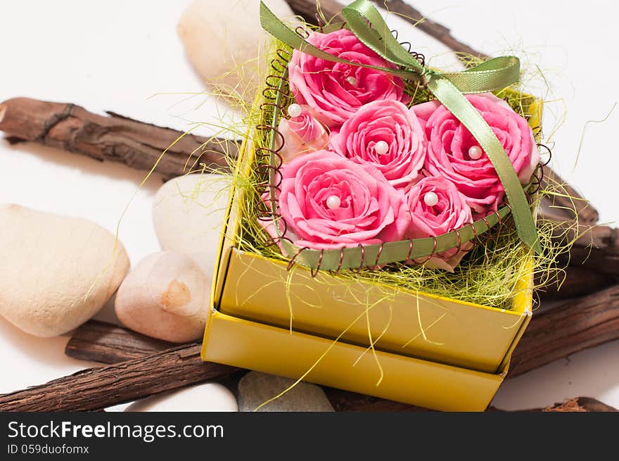 A box of beautiful red roses with wood and stones unde. A box of beautiful red roses with wood and stones unde