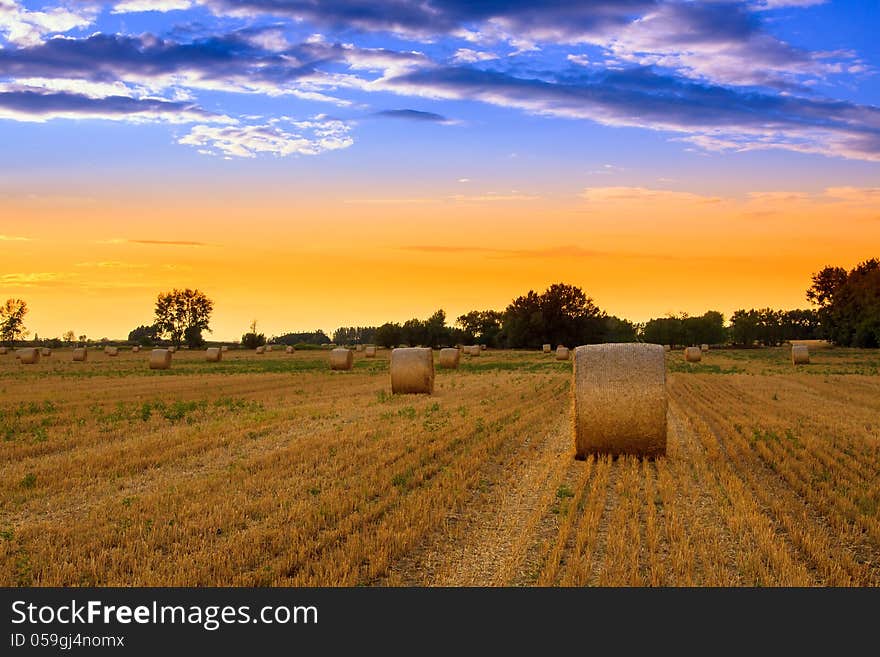 Sunset over the hay bale field