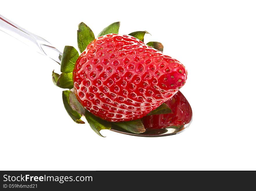 Tasty strawberry inside of a metal spoon isolated on white