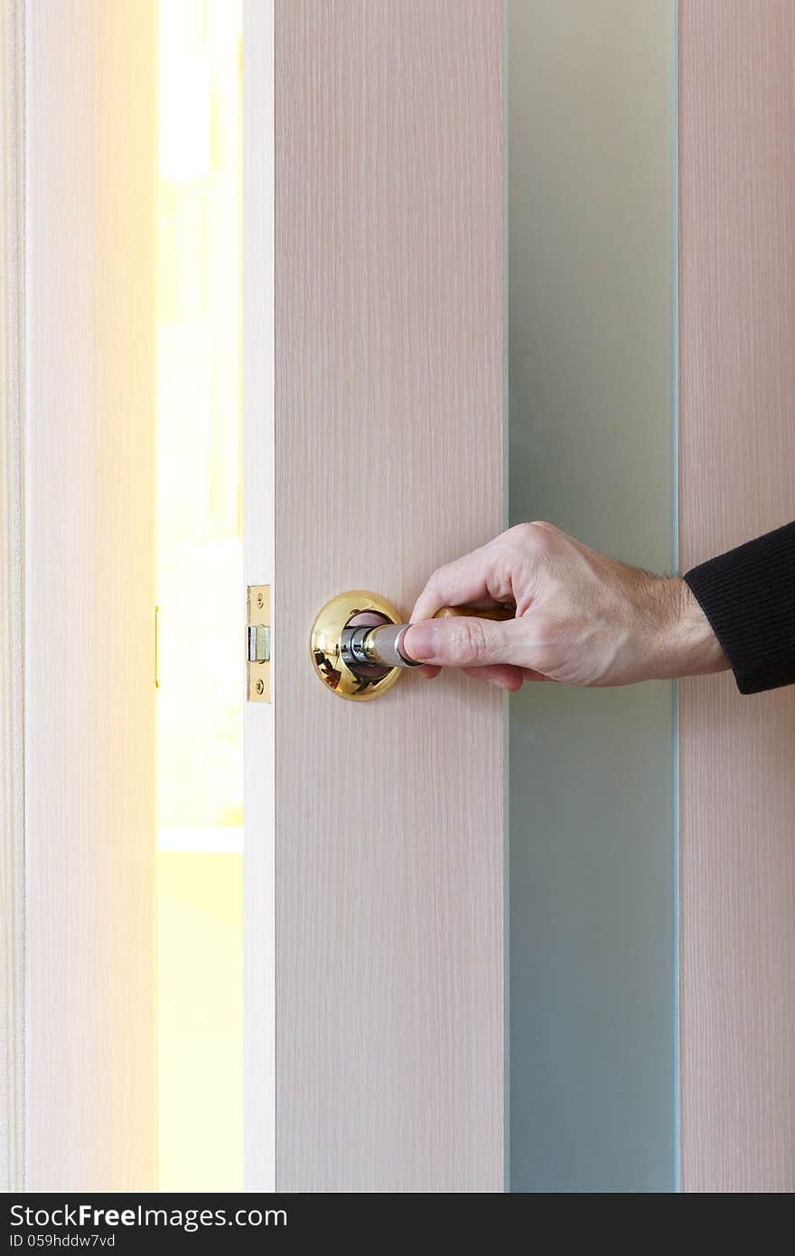 Man hand opening door in light room