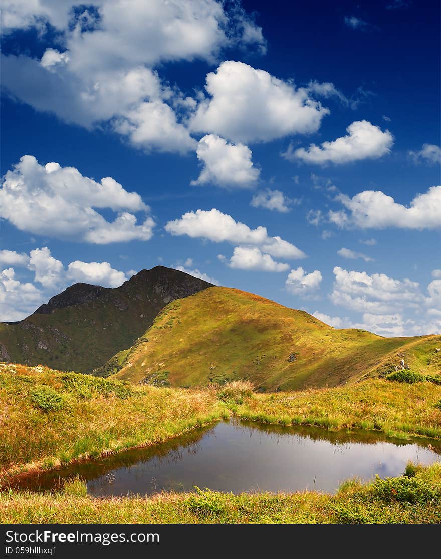 Bright sunny summer landscape with a lake in the mountains. Bright sunny summer landscape with a lake in the mountains.