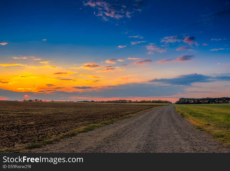 Road in meadows and beautiful sunset