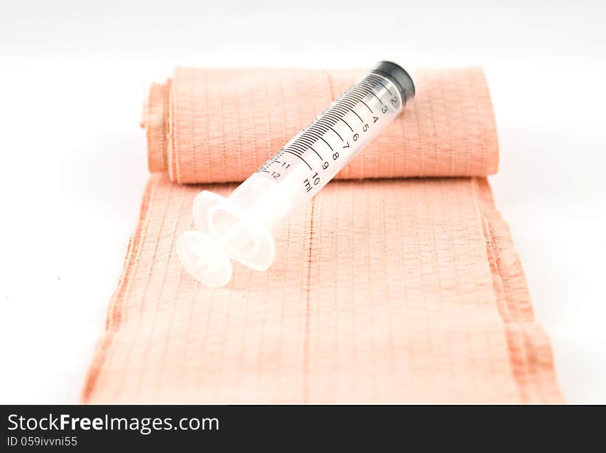 Elastic Bandage and Plastic Syringe on white background. Elastic Bandage and Plastic Syringe on white background