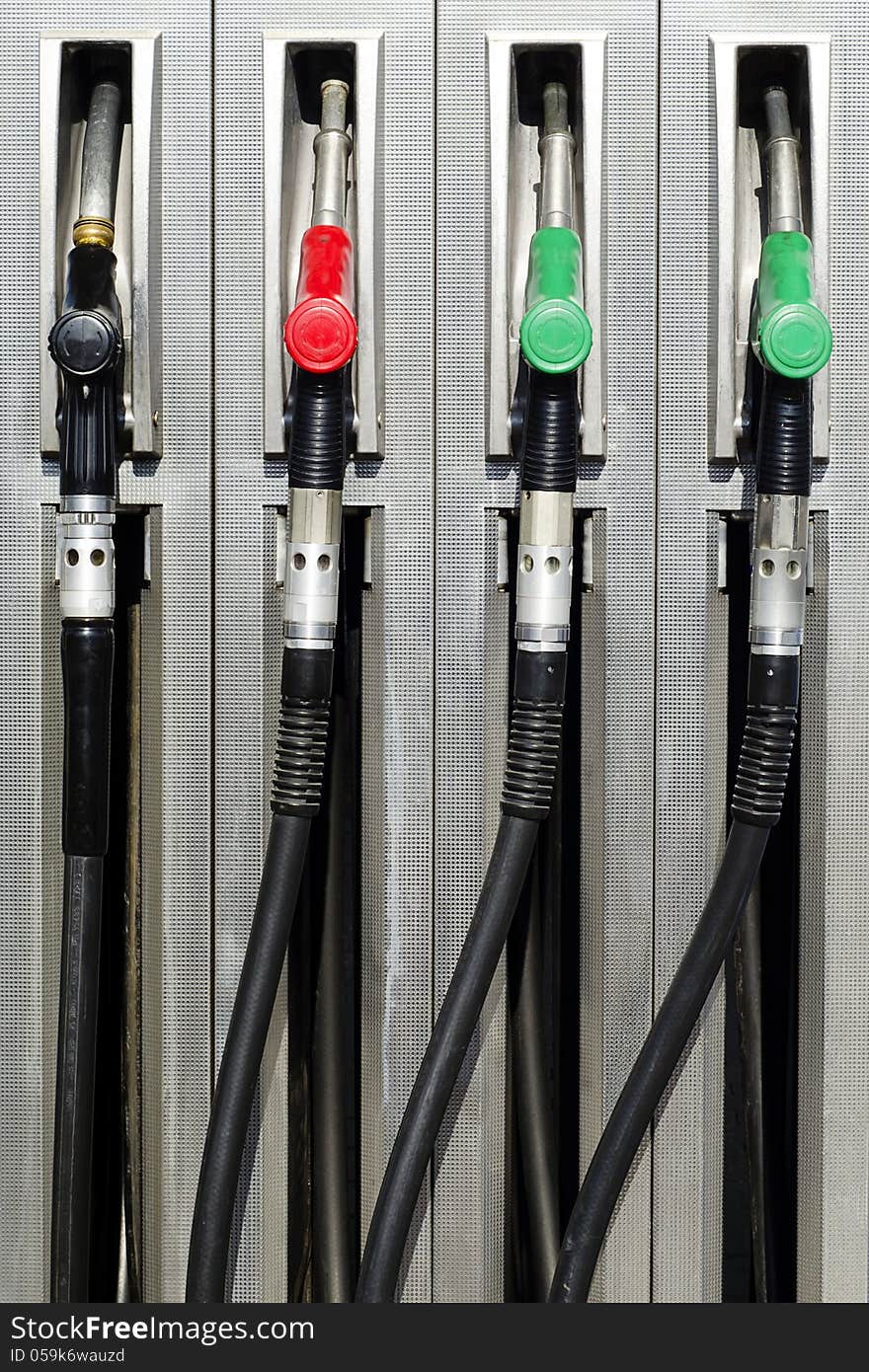 Four refuel nozzles at a petrol or gas station.