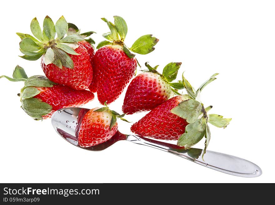 Tasty strawberries with a metal spoon isolated on white