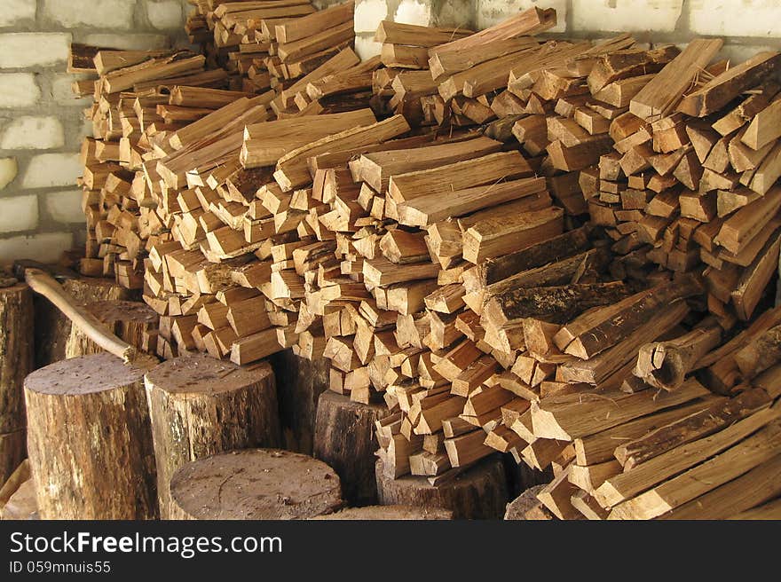 Pile of chopped firewood prepared for winter, stacked and organized in woodshed. Pile of chopped firewood prepared for winter, stacked and organized in woodshed.