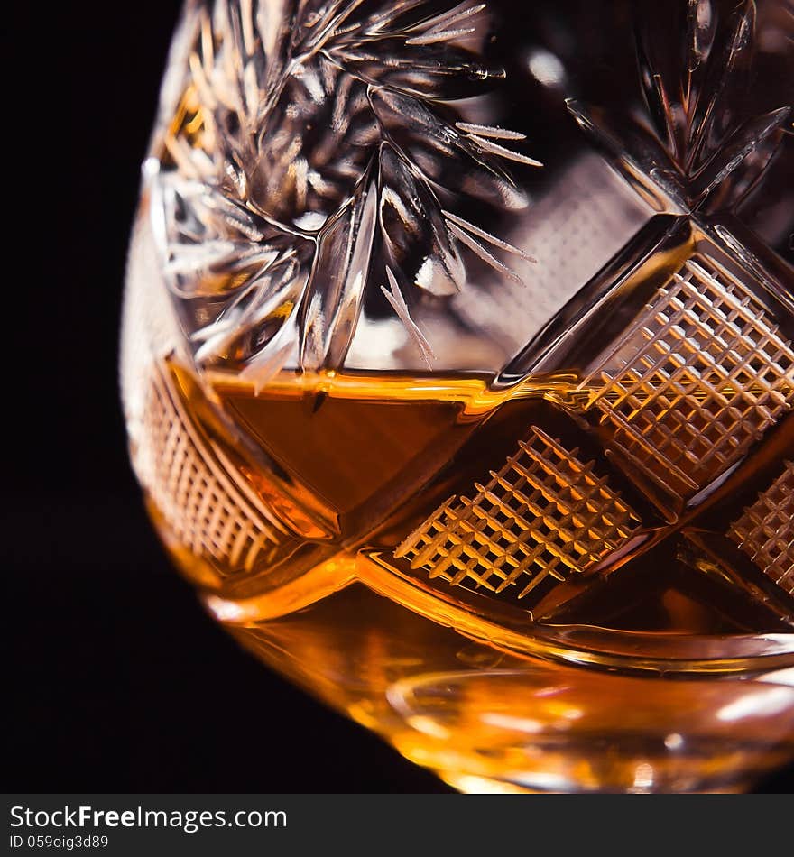 Shot of a cut crystal glass containing brandy.