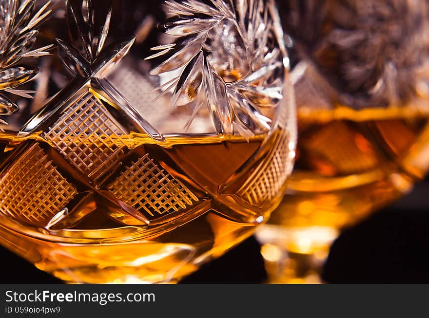 Shot of a cut crystal glass containing brandy.