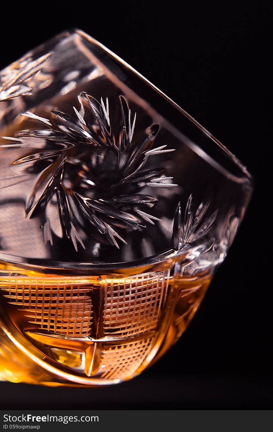 Shot of a cut crystal glass containing brandy.