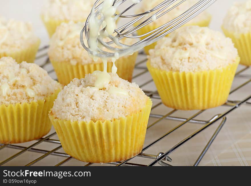 Drizzleing icing on top of lemon cupcakes. Drizzleing icing on top of lemon cupcakes