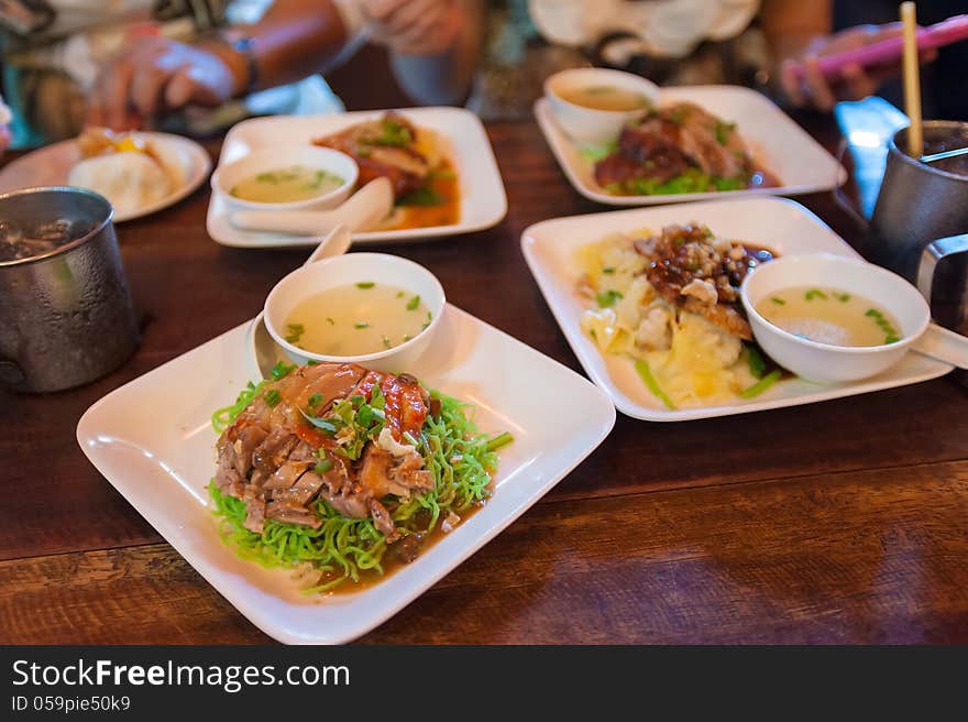 Green noodles with roasted duck on wood desk