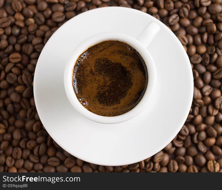 Cup of coffee on coffee beans background