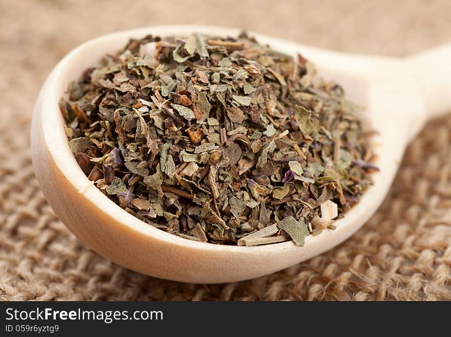 Dried basil in wooden spoon