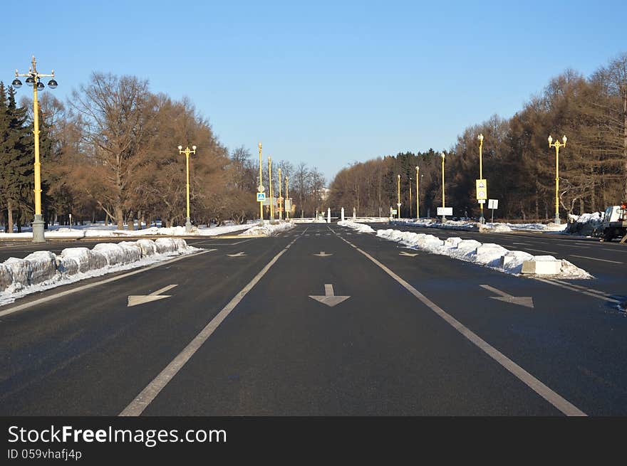 Empty road marked with three wite arrows that prescribe to move straight. Empty road marked with three wite arrows that prescribe to move straight