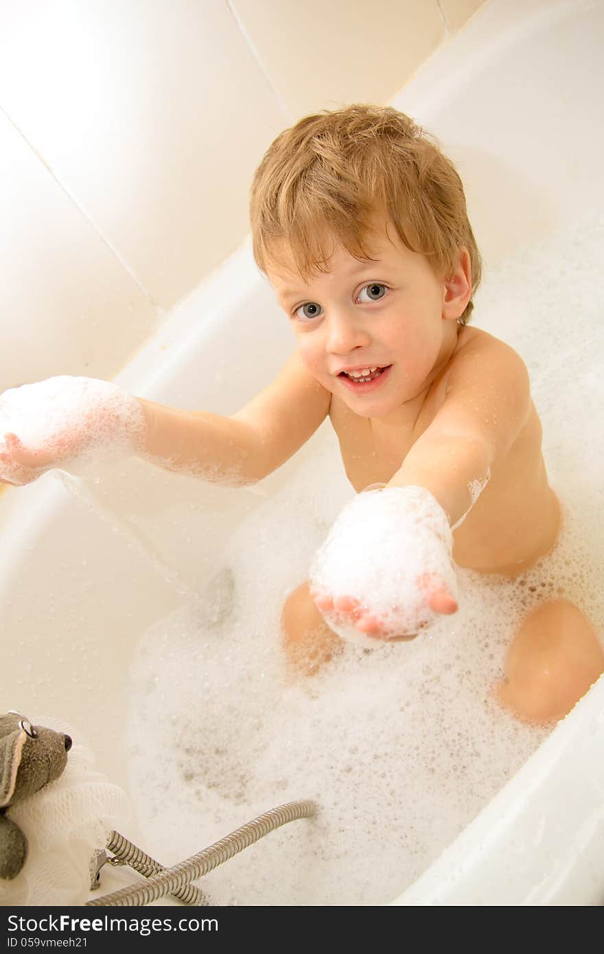 Cute three year old boy taking a bath with foam. This image has attached release.