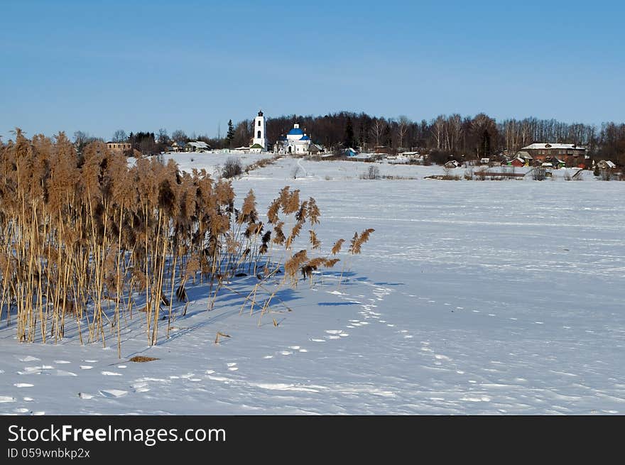 Winter rural landscape with frozen river