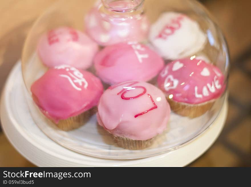 Sweet pink muffins with messages in a glass bowl