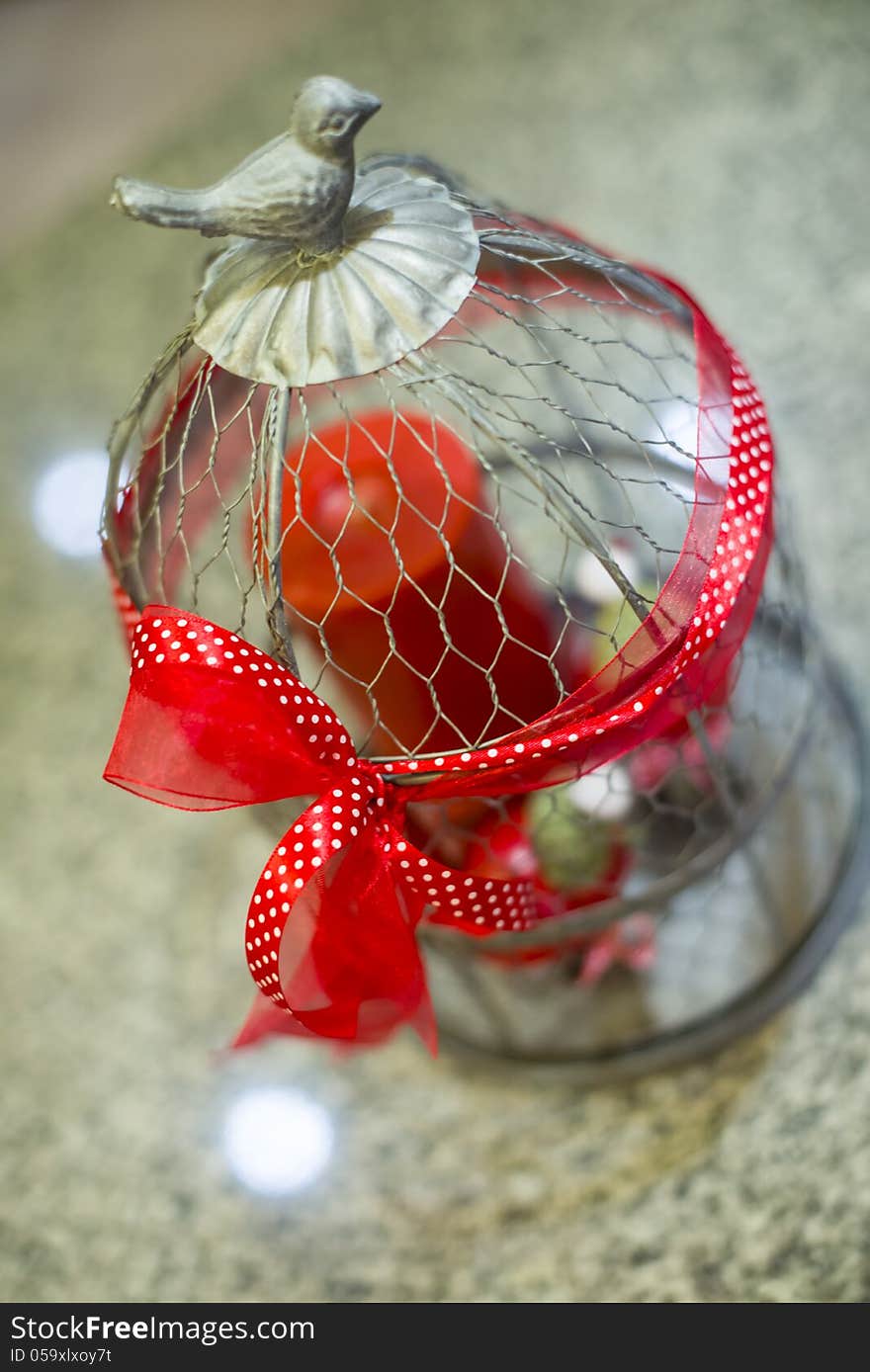 Steel cage ornament with red ribbon