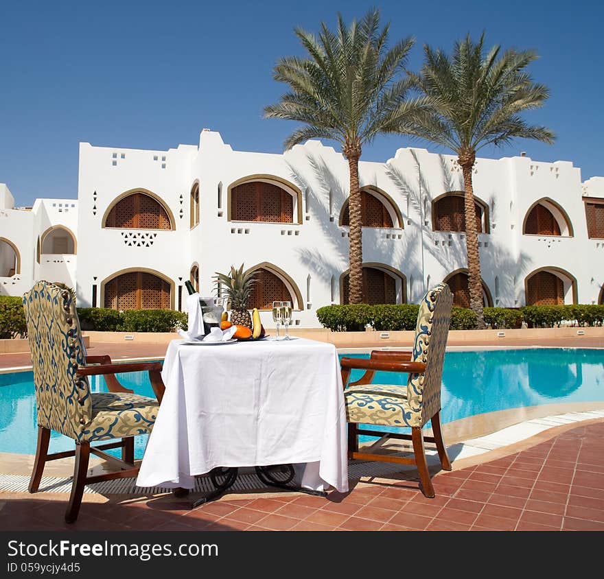 Table with wine and fruit near pool. Table with wine and fruit near pool