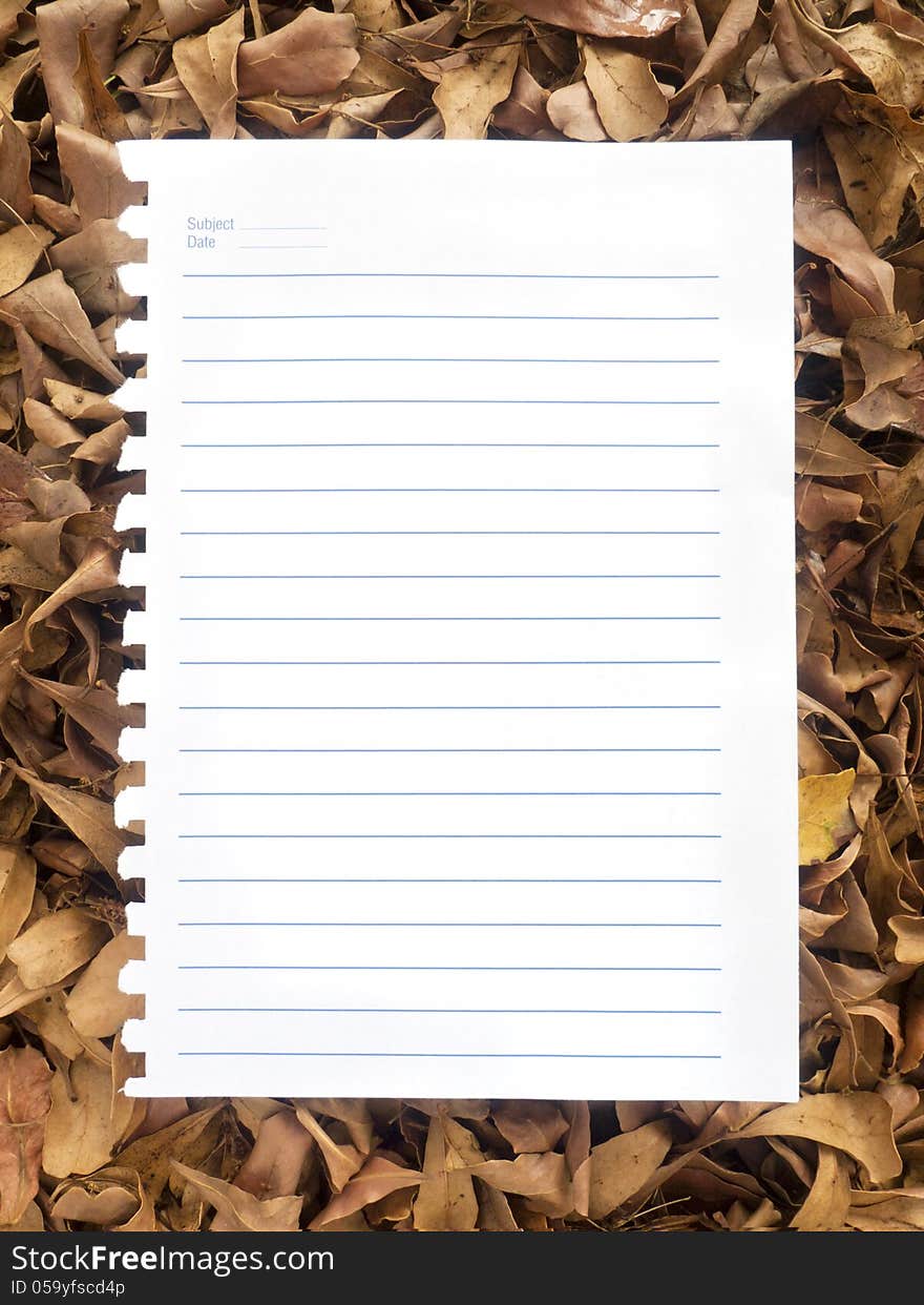 Notebook paper on a pile of autumn leaves. Notebook paper on a pile of autumn leaves.