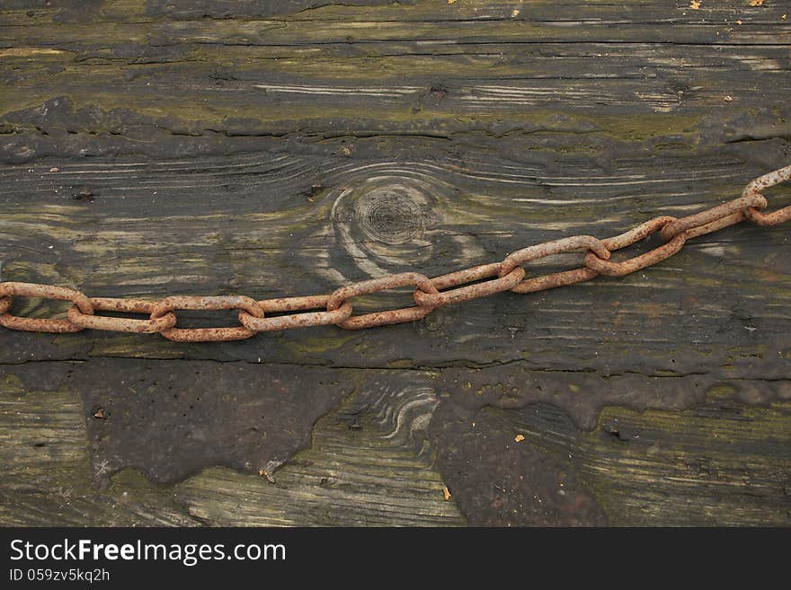 Old chain on green wooden board