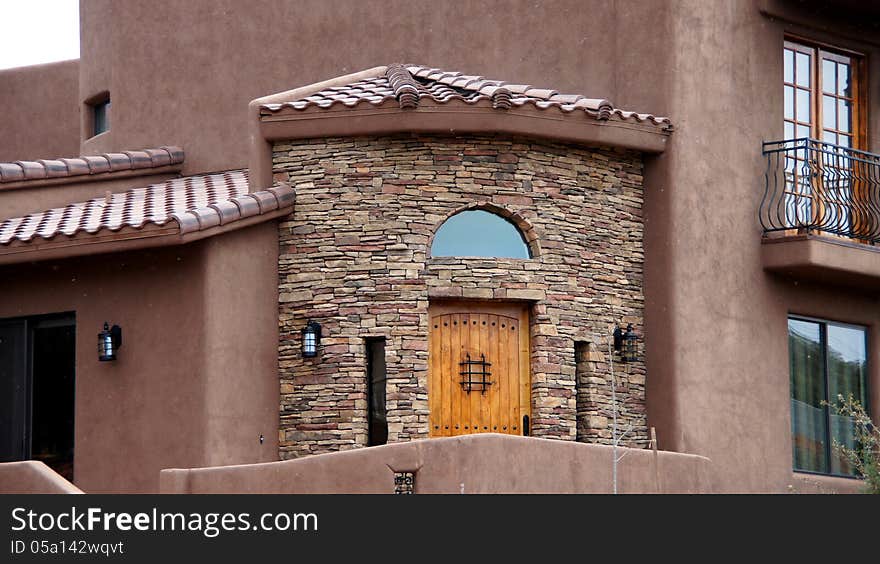 Stucco and brick stone home entrance with wooden door. Stucco and brick stone home entrance with wooden door.