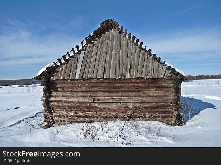 Old wooden barn on a snowy field