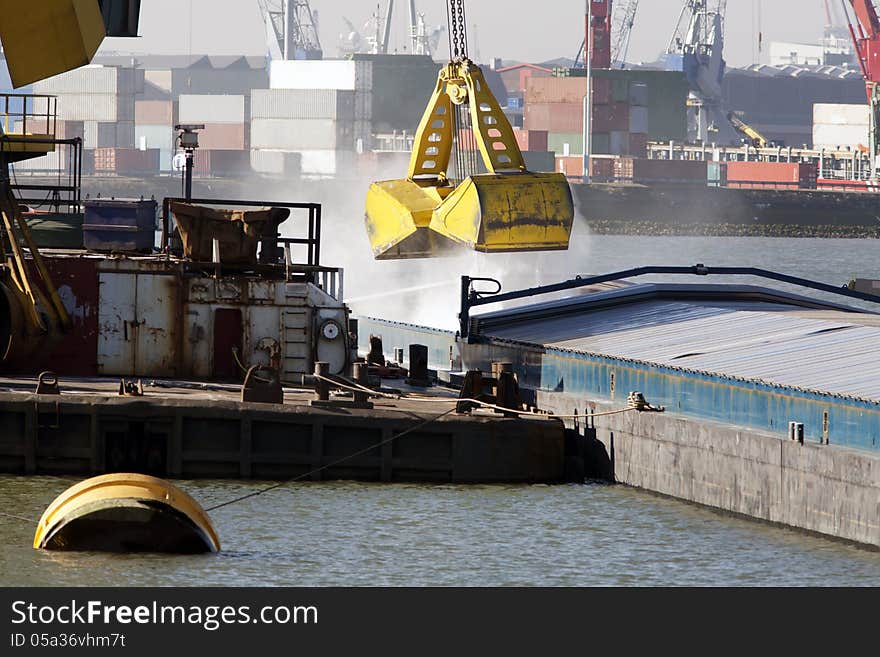 Big grab loading bulk in a barge in the Port of Rotterdam