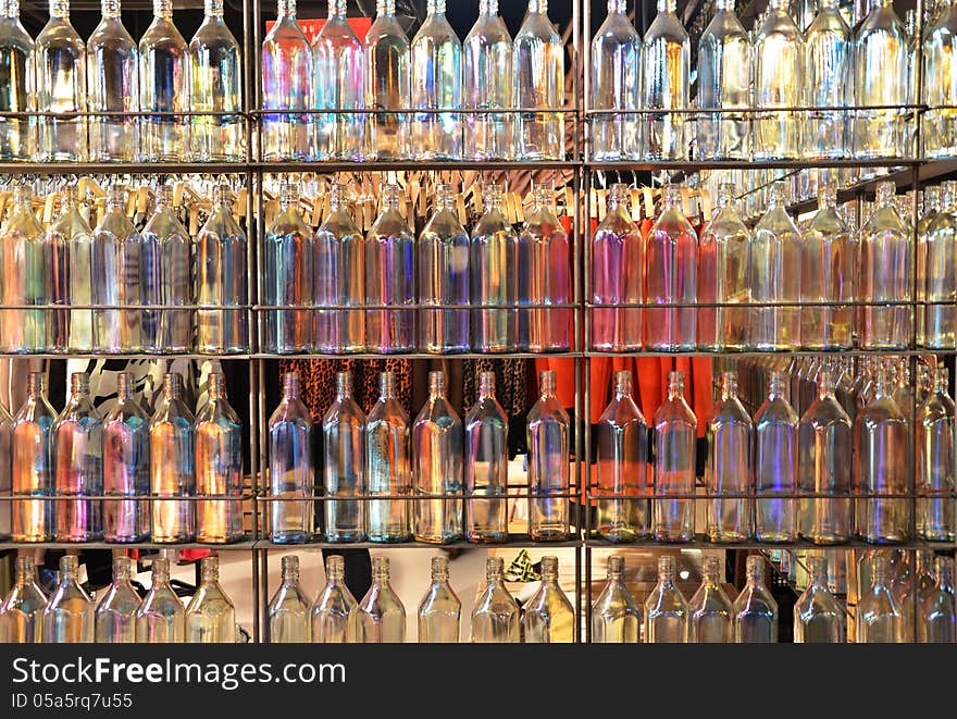 Background of many colorful glass bottles on shelves