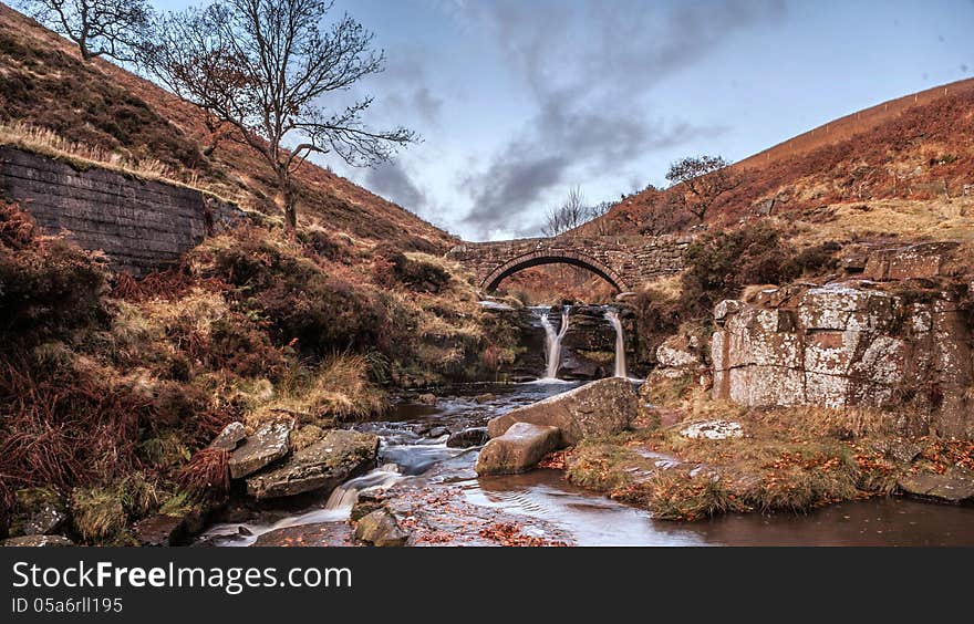 Waterfall and pack horse bridge in the peak District. Three Shire Head.