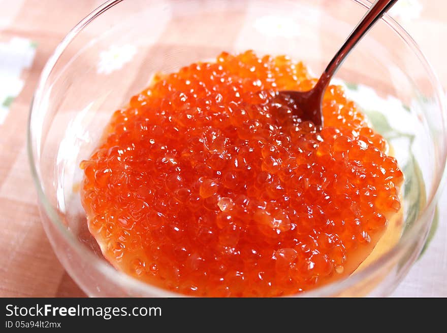 Red caviar in a plate with the spoon