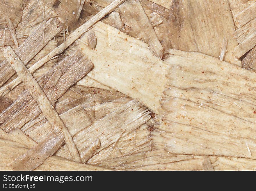 Closeup of a section of particle board clearly showing individual chips of wood and wood grain. Closeup of a section of particle board clearly showing individual chips of wood and wood grain.