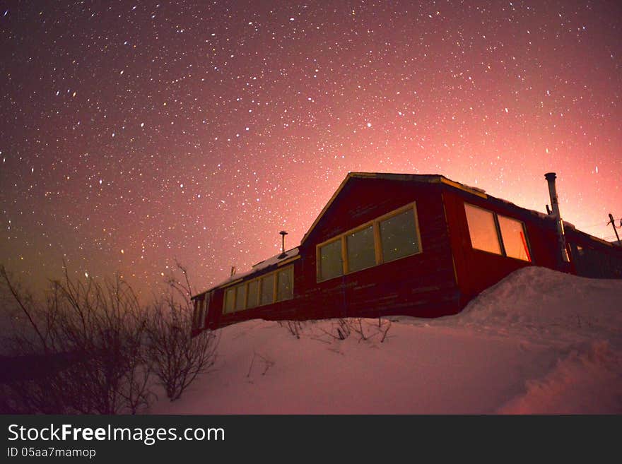 Photograph of a cottage with stars in the background. useful for showing living in cold countries. Photograph of a cottage with stars in the background. useful for showing living in cold countries