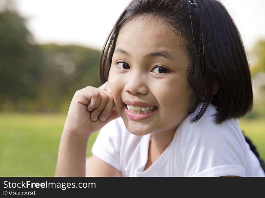 Asian little girl relax and smiling happily in the park