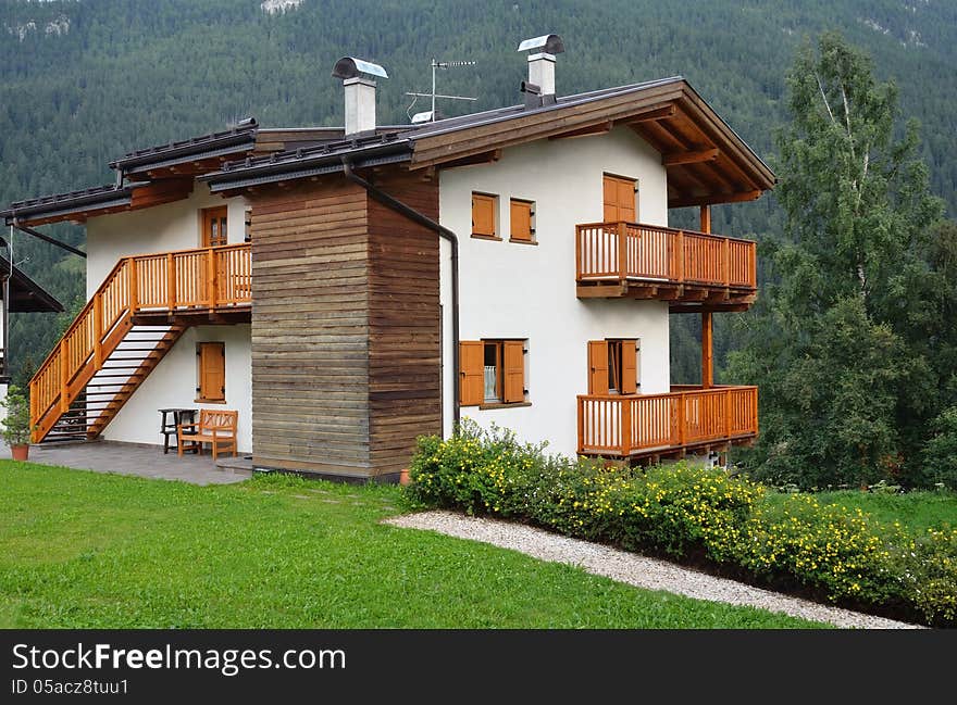 House in Alpine village. Sunny summer day. Dolomites, Val di Fassa, Italy. House in Alpine village. Sunny summer day. Dolomites, Val di Fassa, Italy.