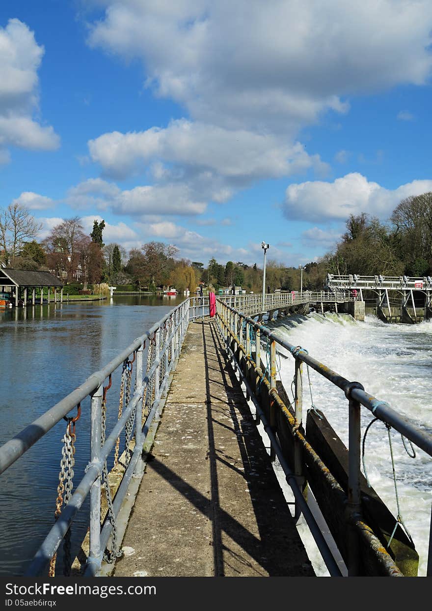 Flood water passing through a Weir and sluice gate on the River Thames in England